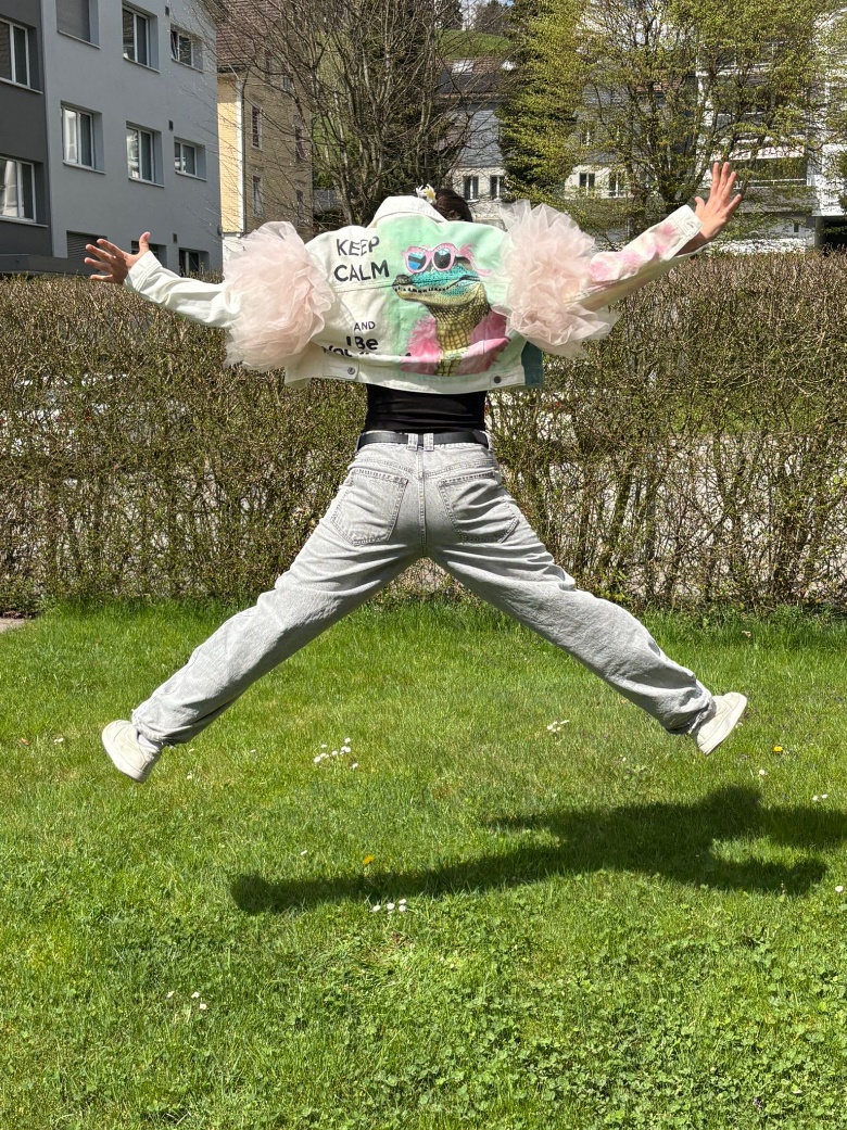 Jana jumping joyfully wearing the finished jacket