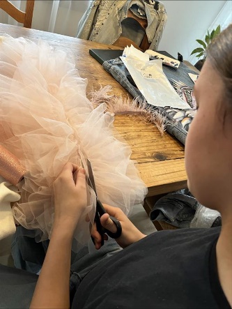 Cutting pink tulle for shoulder decorations