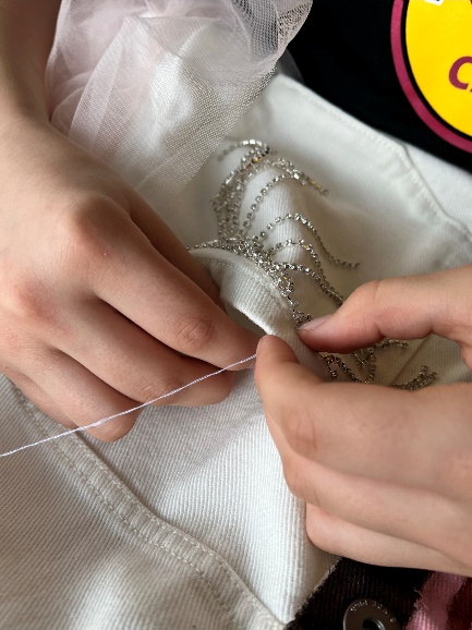 Hand-sewing the glitter curtain detail at the front pocket