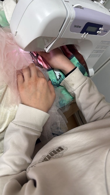 Sewing the pink tulle onto the shoulder with a sewing machine